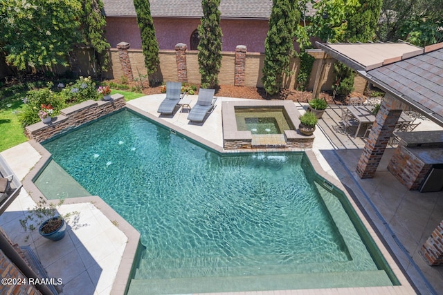 view of swimming pool featuring an in ground hot tub and a patio