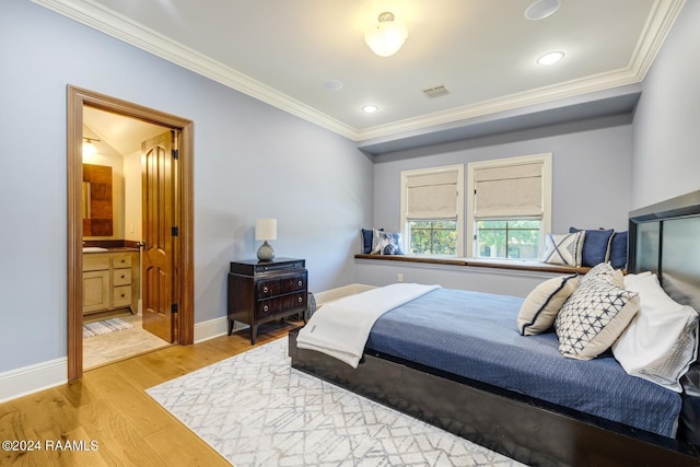 bedroom with wood-type flooring, ensuite bathroom, and crown molding