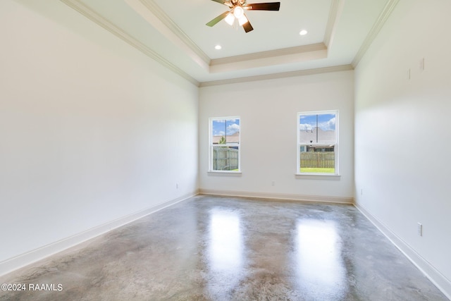 unfurnished room with ceiling fan, a towering ceiling, ornamental molding, a tray ceiling, and concrete flooring