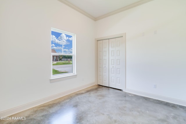 unfurnished bedroom with crown molding, a closet, and concrete floors