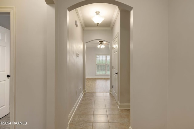 corridor with light tile patterned floors and ornamental molding