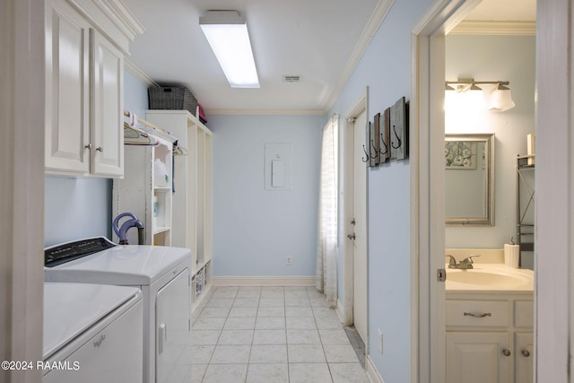 clothes washing area with light tile patterned floors, cabinets, sink, ornamental molding, and washing machine and dryer