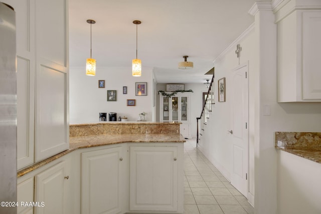 kitchen with pendant lighting, light tile patterned floors, white cabinets, light stone counters, and kitchen peninsula