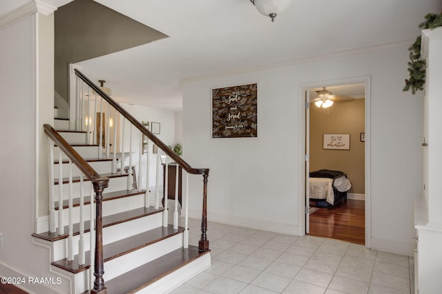 staircase featuring ceiling fan, tile patterned floors, and ornamental molding