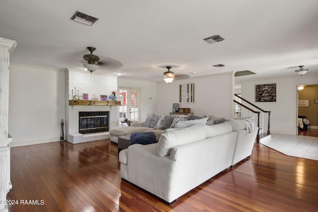 living room with ceiling fan, a fireplace, hardwood / wood-style flooring, and crown molding