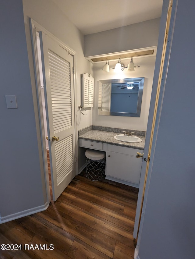 bathroom featuring vanity, baseboards, and wood finished floors