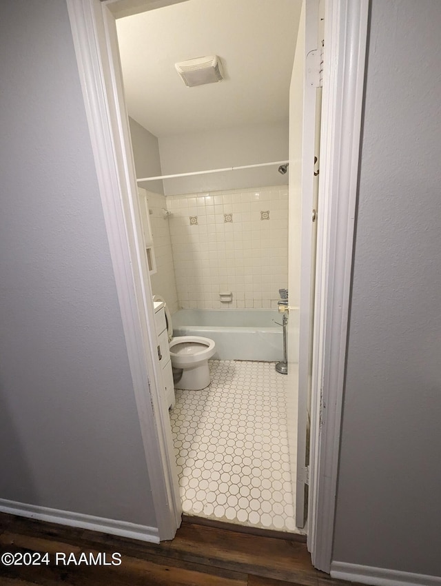 bathroom with toilet, baseboards, visible vents, and shower / washtub combination