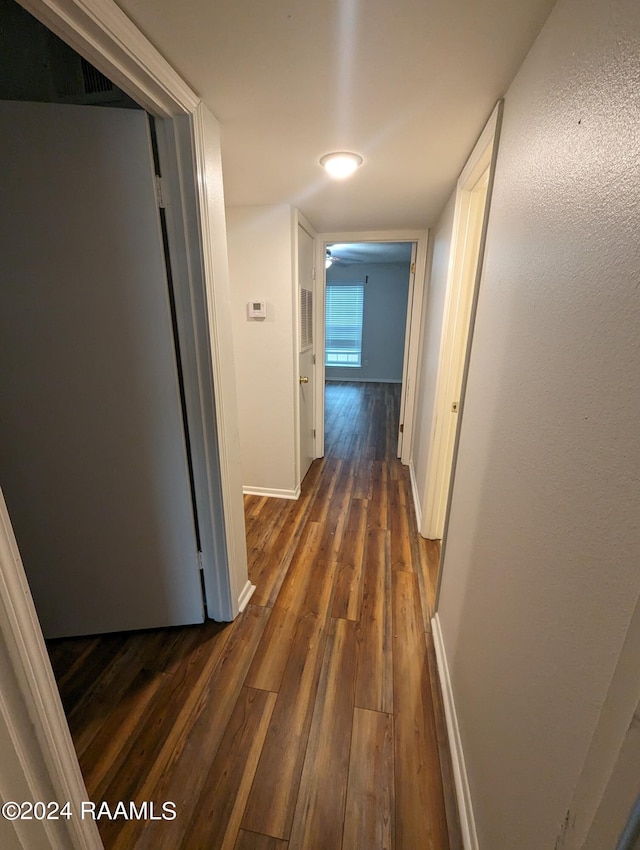 hall featuring dark wood finished floors and baseboards