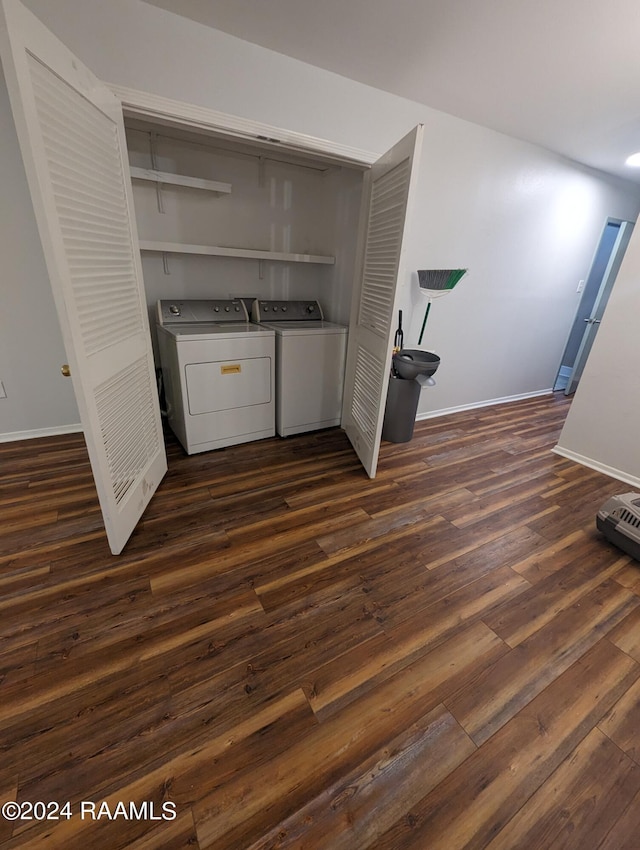 laundry area with dark wood-style floors, laundry area, washing machine and clothes dryer, and baseboards