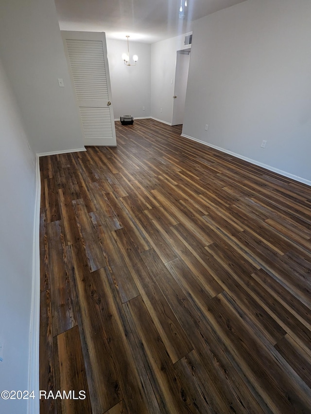 empty room with visible vents, baseboards, and dark wood-type flooring