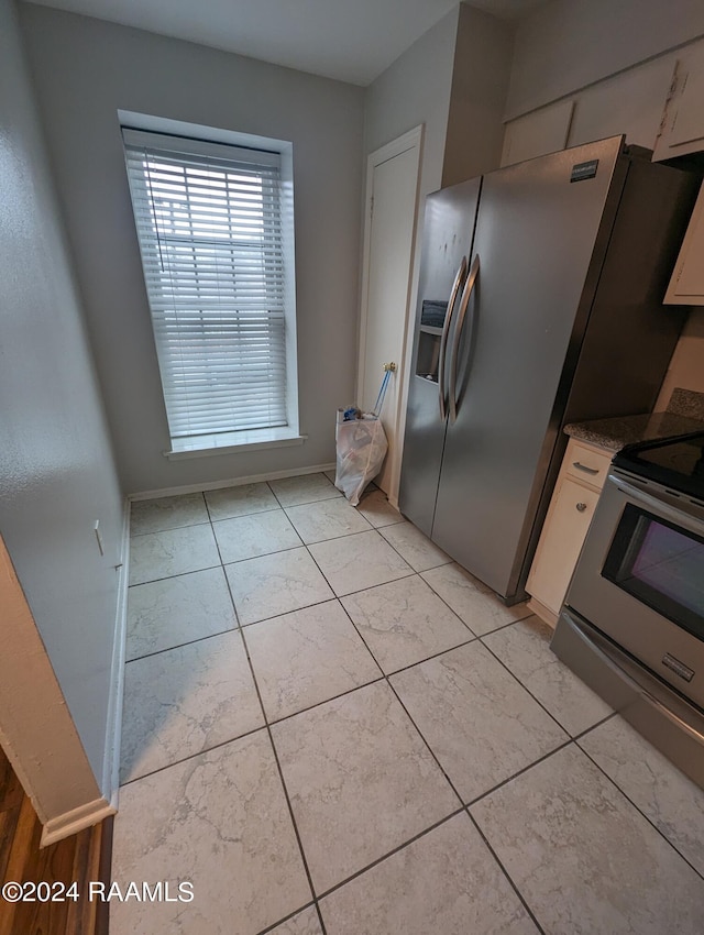 kitchen featuring appliances with stainless steel finishes, light countertops, white cabinetry, and light tile patterned floors