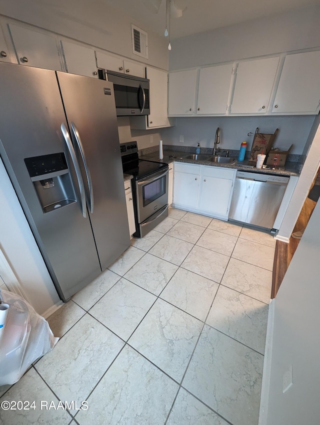 kitchen featuring appliances with stainless steel finishes, white cabinets, visible vents, and a sink