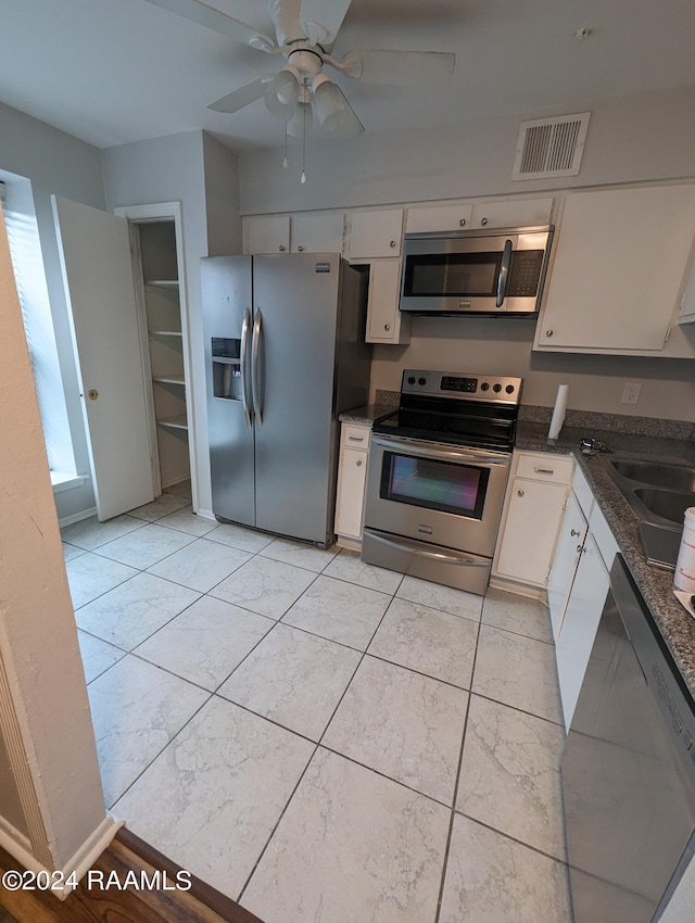 kitchen featuring a sink, visible vents, white cabinetry, appliances with stainless steel finishes, and dark stone counters