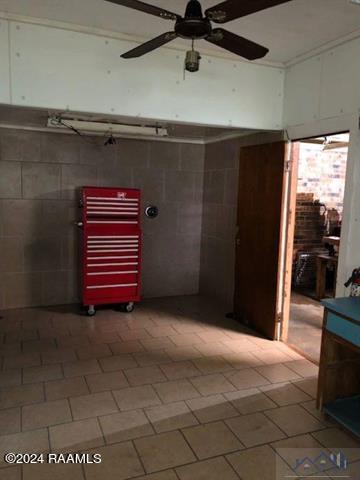 interior space featuring tile walls, tile flooring, ceiling fan, and radiator heating unit