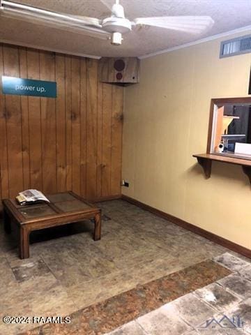 basement with wood walls, ornamental molding, and tile floors