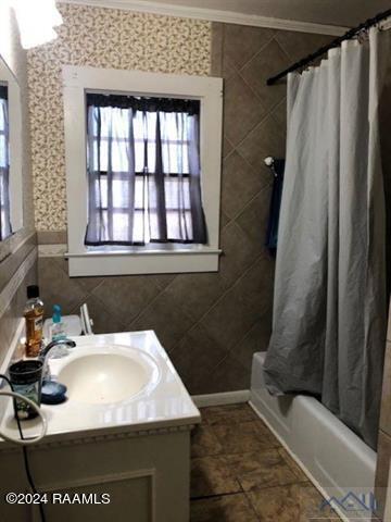 bathroom with crown molding, shower / tub combo, tile floors, tile walls, and vanity