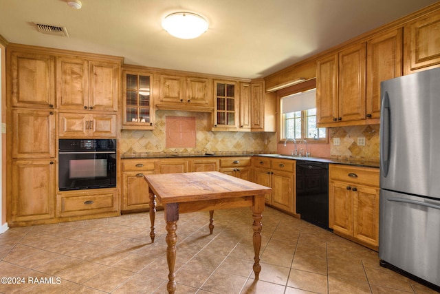 kitchen with backsplash, black appliances, sink, light tile patterned floors, and light stone counters