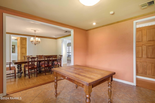 dining area with crown molding, an inviting chandelier, and hardwood / wood-style flooring