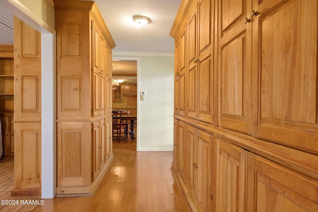 hall with light hardwood / wood-style floors and crown molding