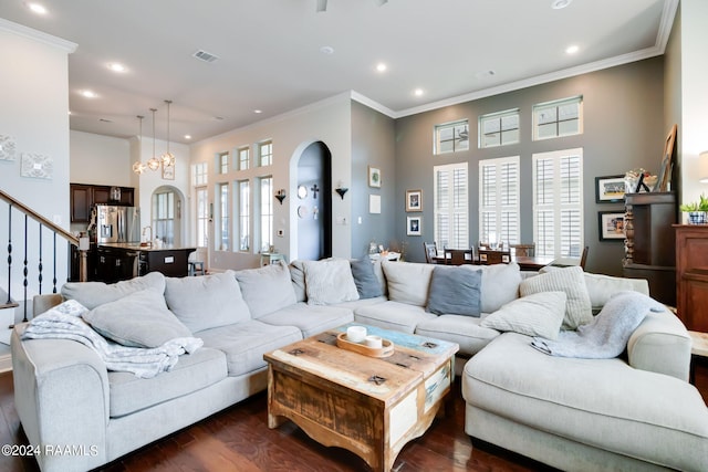 living room featuring an inviting chandelier, dark hardwood / wood-style floors, and ornamental molding