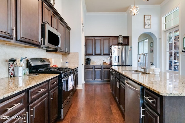 kitchen featuring ornamental molding, stainless steel appliances, dark wood-type flooring, sink, and hanging light fixtures