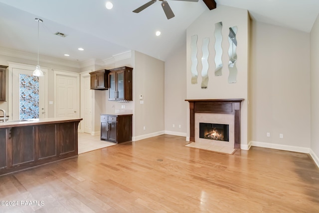 unfurnished living room featuring ceiling fan, light hardwood / wood-style floors, a high end fireplace, and lofted ceiling with beams