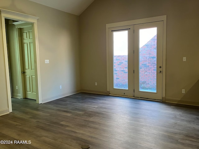 empty room with dark hardwood / wood-style flooring and vaulted ceiling