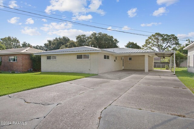 view of front of property featuring a carport and a front yard