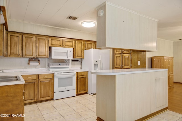 kitchen with light tile patterned floors, white appliances, crown molding, and sink