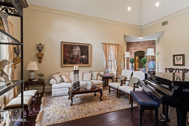 sitting room with ornamental molding, a towering ceiling, and dark wood-type flooring