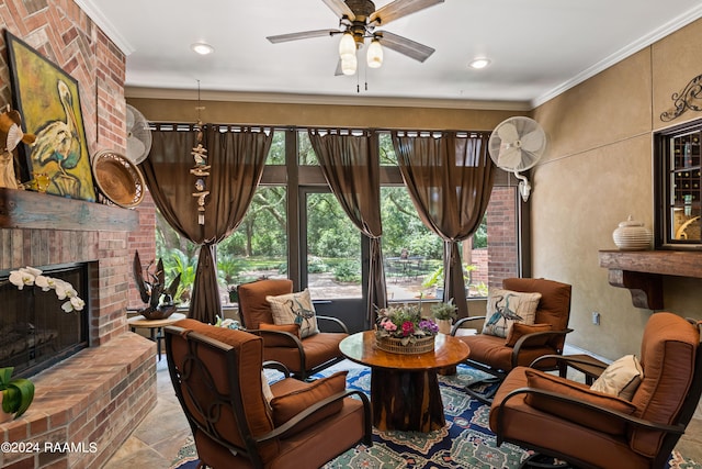 sitting room featuring a brick fireplace, ceiling fan, and ornamental molding