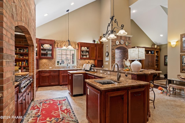 kitchen with high vaulted ceiling, a center island with sink, sink, hanging light fixtures, and stainless steel appliances