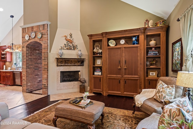 living room with a chandelier, dark hardwood / wood-style floors, high vaulted ceiling, and sink