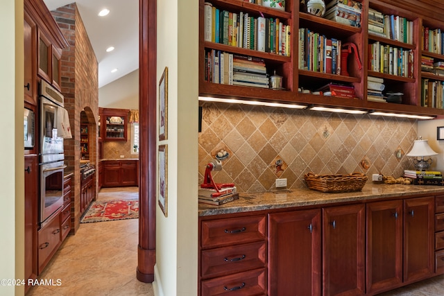 kitchen featuring tasteful backsplash, stone countertops, and appliances with stainless steel finishes