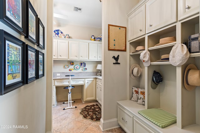 mudroom with crown molding and light tile patterned flooring