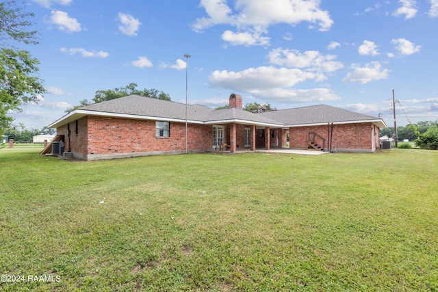 back of house with a lawn and a patio