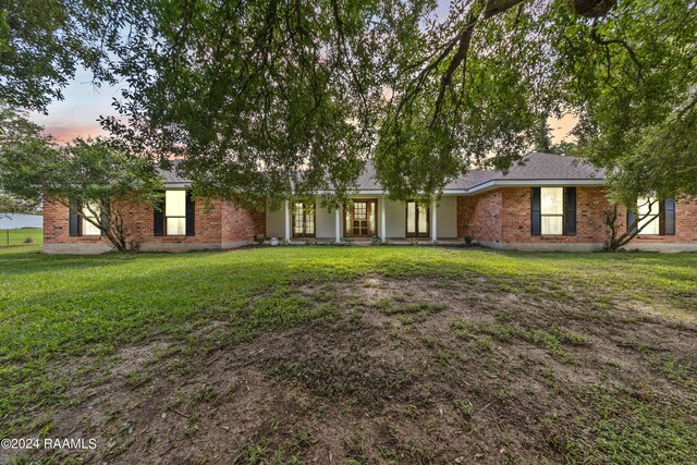 single story home featuring a lawn