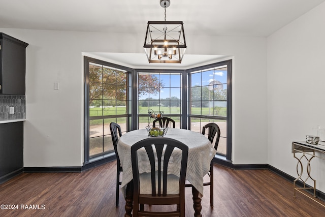 dining room with dark wood-type flooring and a chandelier