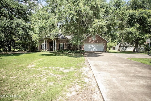 view of property hidden behind natural elements with a garage, an outbuilding, and a front yard