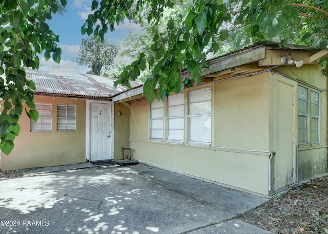 view of exterior entry with a patio area