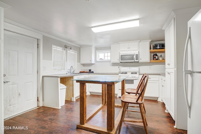 kitchen with white cabinetry, dark hardwood / wood-style flooring, white appliances, and tasteful backsplash