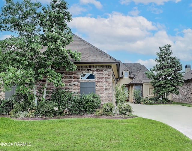 french country home featuring a front yard