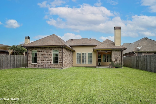 rear view of property with a patio and a yard