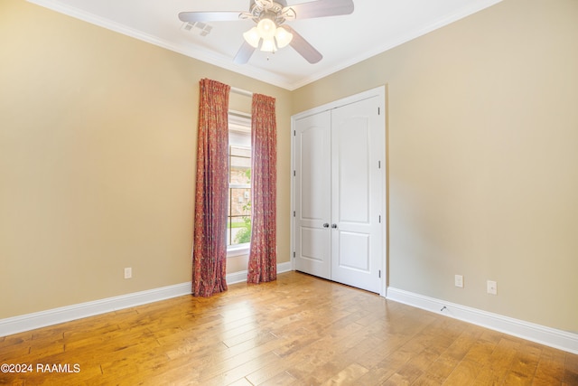 unfurnished bedroom featuring a closet, light hardwood / wood-style floors, ornamental molding, and ceiling fan