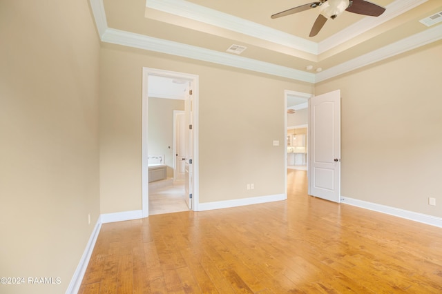 spare room with ornamental molding, ceiling fan, a tray ceiling, and light hardwood / wood-style floors