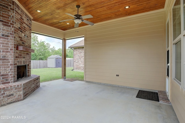 view of patio / terrace with ceiling fan, an outdoor brick fireplace, and a shed