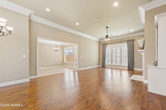 unfurnished living room featuring ceiling fan with notable chandelier, plenty of natural light, wood finished floors, and crown molding