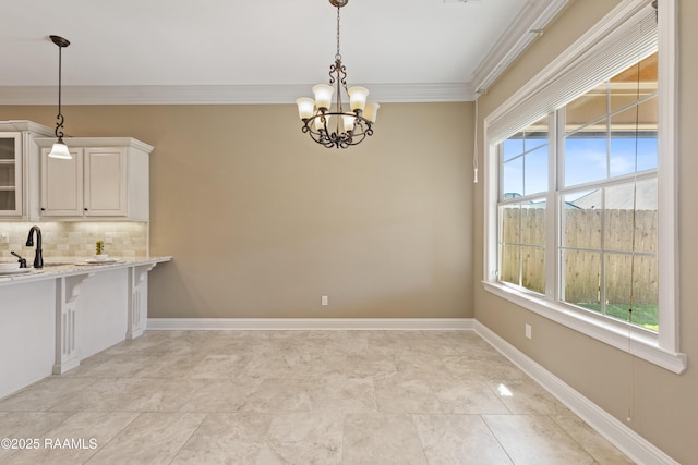 unfurnished dining area with baseboards, an inviting chandelier, a wealth of natural light, and crown molding