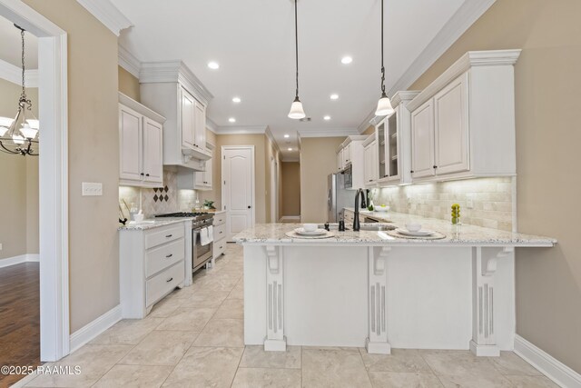 kitchen featuring a peninsula, a breakfast bar, ornamental molding, appliances with stainless steel finishes, and glass insert cabinets