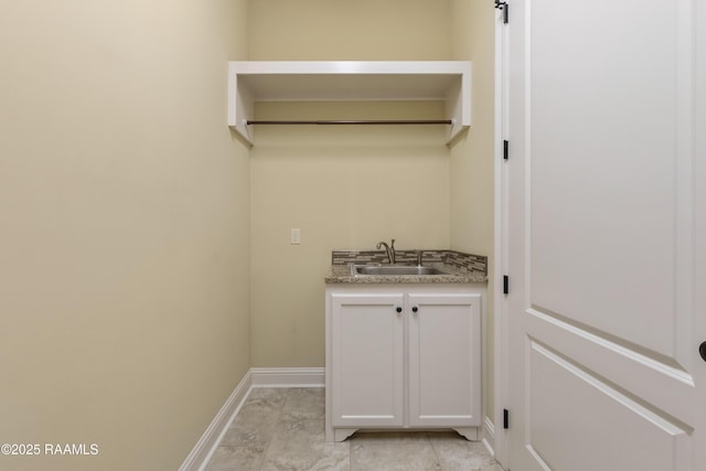 washroom with a sink and baseboards